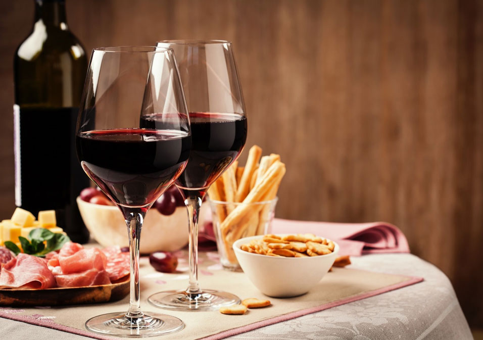 table dressée : verres de vin, plateau de charcuterie